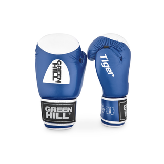 Ein Paar blaue Echtleder-Boxhandschuhe des Modells Tiger von Green Hill stehend vor weißem Hintergrund. Der linke Handschuh zeigt die Frontansicht des Handrückens mit dem markanten, runden weiß-schwarzen Green-Hill-Logo und der weißen Trefferfläche. Der rechte Handschuh ist seitlich gedreht, sodass der weiße Längsschriftzug 'Tiger' sowie die Daumenpartie gut sichtbar sind.