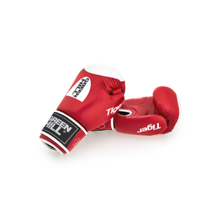 Ein Paar rote Echtleder-Boxhandschuhe des Modells Tiger von Green Hill vor weißem Hintergrund. Der linke Handschuh liegt auf der Seite und zeigt das weiße Green-Hill-Logo auf dem Handrücken sowie den Schriftzug Tiger. Auf dem Klettverschluss befindet sich ein schwarz-weißes Marken-Label. Der rechte Handschuh liegt leicht dahinter, sodass die Innenseite der Faust sichtbar ist.