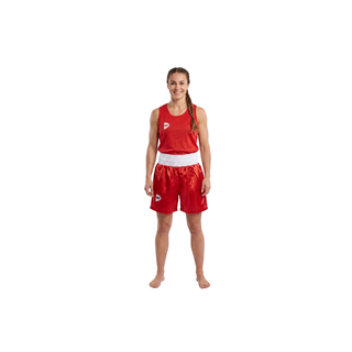 Ein Studiofoto einer lächelnden Frau in einem roten Box-Set vor weißem Hintergrund. Sie trägt ein ärmelloses, rotes Mesh-Oberteil mit einem kleinen Logo auf der rechten Brustseite. Die dazu passende rote Boxershorts hat einen breiten, weißen Elastikbund und zeigt einen seidigen Glanz. Die Athletin steht barfuß in einer neutralen Frontalansicht.