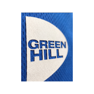 Nahaufnahme eines weißen, halbkreisförmigen Green Hill Logos, das auf blauem, fein perforiertem Mesh-Gewebe appliziert ist; die Markenschrift ist präzise aus dem weißen Material ausgestanzt, sodass der blaue Stoff darunter sichtbar wird.

Dieses Detailfoto verdeutlicht die hochwertige Verarbeitung und die feine Struktur des atmungsaktiven Materials.