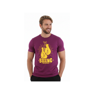 Ein lächelndes, sportliches Model mit blonden Haaren und Bart trägt das bordeauxrote T-Shirt „Fighting Spirit“. Der gelbe Frontprint zeigt hängende Boxhandschuhe und den markanten Schriftzug „BOXING“ auf weißem Hintergrund.